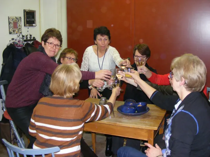 Een groep proost aan tafel in het atelier