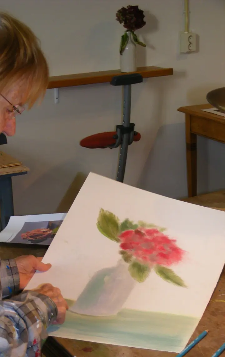 Iemand laat een bloem in pastelkrijt zien